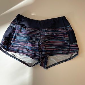 Athelta running shorts. Multi colored—navy with pink/peach stripes.